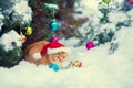 Red kitten,wearing Santa hat sitting near Christmas tree Royalty Free Stock Photo