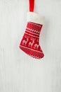 Red Knitted Christmas Stocking Hanging on White Wood Barn Board Fire Place. Scandinavian Ornaments. Festive Bright Cozy Atmosphere