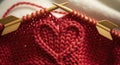Red knitted fabric with heart pattern and knitting needles Royalty Free Stock Photo