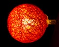 Red knitted fabric lightbulb with strong defocus macrophotography