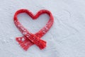 Red knitted scarf lies on the snow in the shape of a heart, welcome winter concept, winter holidays, walks, happy new year and chr