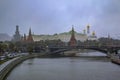 Red Kremlin wall and tower, traffic on Kremlevskaya Embankment by the Moskva River in a snow storm in Moscow, Russia