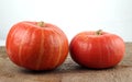 Red kuri squashes on a rough woody texture background. Royalty Free Stock Photo