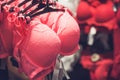 Red lace bra hanging on rack in underwear store. Toned with selective focus Royalty Free Stock Photo