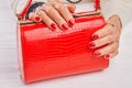 Red lacquered bag in female hands. Royalty Free Stock Photo