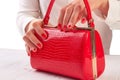 Red lacquered handbag in female hands. Royalty Free Stock Photo