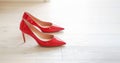 Red lacquered high heel shoes for women on parquet floor Royalty Free Stock Photo