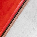 Red lacquered wood and raw cement surface close up background.