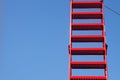 Red ladder from metal against the blue sky, generous copy spac Royalty Free Stock Photo