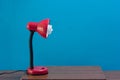 Red Lamp On Vintage Wood Desk On Blue Wall Background. Royalty Free Stock Photo