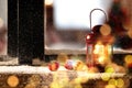 Red lantern with candle and bells near window outdoors. Christmas eve