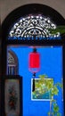 Red lantern seen through the door in a blue house in Penang Royalty Free Stock Photo