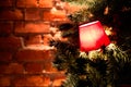Red lanterns on a branch of a Christmas tree on a red brick wall background Royalty Free Stock Photo
