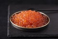 red large salted caviar in a small black plate