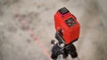 Red laser level tool projecting a line on the floor
