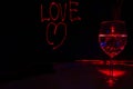 Red Laser light painting of Love sign for valentines day in a dark background with wine glass for the celebration Royalty Free Stock Photo