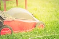 Red lawn mower on a green lawn/lawn mower on the grass.  Selective focus Royalty Free Stock Photo