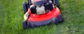 Red Lawn Mower in Lush Green Grass Mowing Lawn Royalty Free Stock Photo