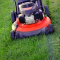 Red Lawn Mower in Lush Green Grass Mowing Lawn Royalty Free Stock Photo