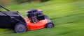 Red Lawn Mower in Lush Green Grass Mowing Lawn Royalty Free Stock Photo