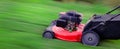 Red Lawn Mower in Lush Green Grass Mowing Lawn Royalty Free Stock Photo