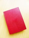 Red leather bound book on brown table top