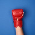 Red leather boxing glove on a female hand on a blue background Royalty Free Stock Photo