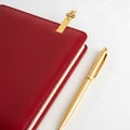 Red leather notebook with gold pen and bookmark isolated on white background Royalty Free Stock Photo
