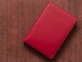 red leather notebook over wood background