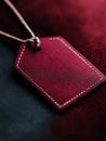 Red leather tag with stitching on a dark background. Royalty Free Stock Photo