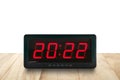 Red led light illuminated numbers 2022 on digital electric alarm clock face on wooden table top Royalty Free Stock Photo