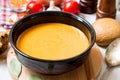 Red lentil cream soup in dark ceramic bowl Royalty Free Stock Photo