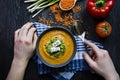 Red lentil cream soup decorated with fresh vegetables and herbs. A man eats soup. Veggie concept. Proper nutrition