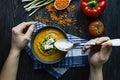 Red lentil cream soup decorated with fresh vegetables and herbs. A man eats soup. Veggie concept. Proper nutrition Royalty Free Stock Photo