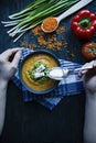 Red lentil cream soup decorated with fresh vegetables and herbs. A man eats soup. Veggie concept. Proper nutrition Royalty Free Stock Photo