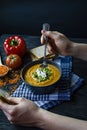 Red lentil cream soup decorated with fresh vegetables and herbs. A man eats soup. Veggie concept. Proper nutrition Royalty Free Stock Photo