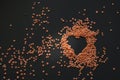 Red lentil heart on dark wooden table Royalty Free Stock Photo