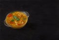 Red lentil soup in a glass bowl with spices, onion and garlic on a black background. Copy spaes Royalty Free Stock Photo