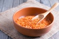 Red lentils in ceramic bowl on wooden table Royalty Free Stock Photo