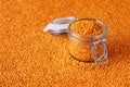 Red lentils in a glass jar with lentils background