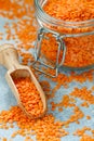 Red lentils in a glass jar and in a wooden scoop