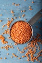 Red lentils in a metal measuring cup on a blue natural wood background. Top view. Royalty Free Stock Photo