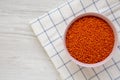 Red lentils in a pink bowl over white wooden surface, top view. Flat lay, overhead, from above. Copy space Royalty Free Stock Photo