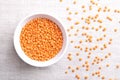 Red lentils, lentils with husk removed, in a white bowl on linen Royalty Free Stock Photo