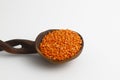 Red lentils in wooden spoon isolated on white background. Top view. Royalty Free Stock Photo