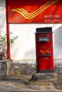 Red letter box with background of India Post, Pune University campus, Pune