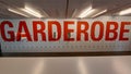 Red letters `GARDEROBE` on wall of lockers