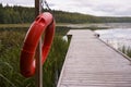 Red life ring buoy hanging from a pole ,next to a pier Royalty Free Stock Photo