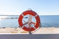 Red life safety ring buoy at port harbor prevent drowning in sea cannot swim Royalty Free Stock Photo