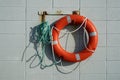 Red life saving ring hanging on a breeze block wall Royalty Free Stock Photo